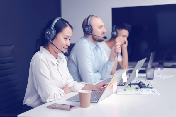 Imagem de uma mulher e um homem em atendimento com headset