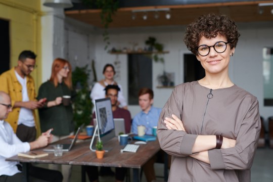 Imagem perfil de uma mulher líder e liderados ao fundo