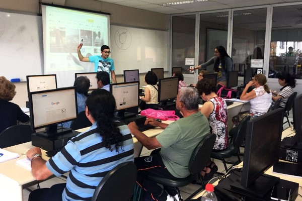 Imagem de sala de informática da fecap com pessoas da terceira idade