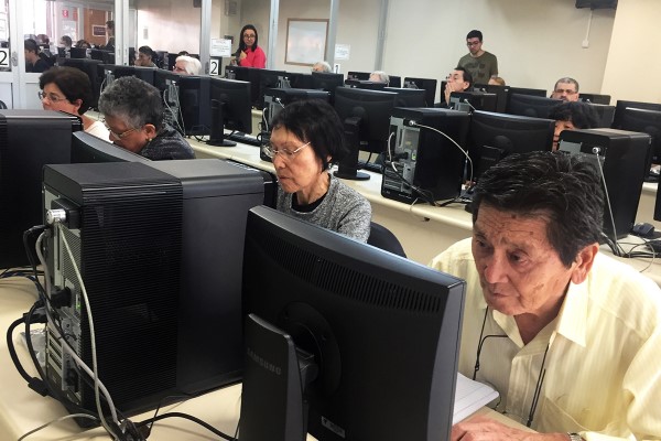 Imagem de sala de informática da fecap com pessoas da terceira idade