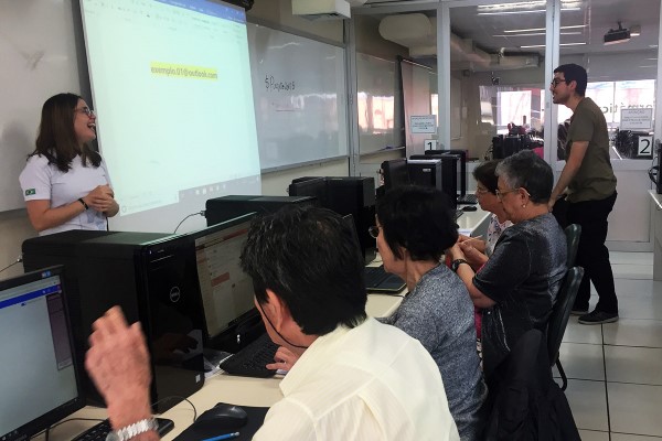 Imagem de sala de informática da fecap com pessoas da terceira idade