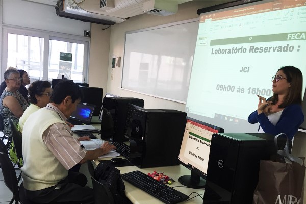 Imagem de sala de informática da fecap com pessoas da terceira idade