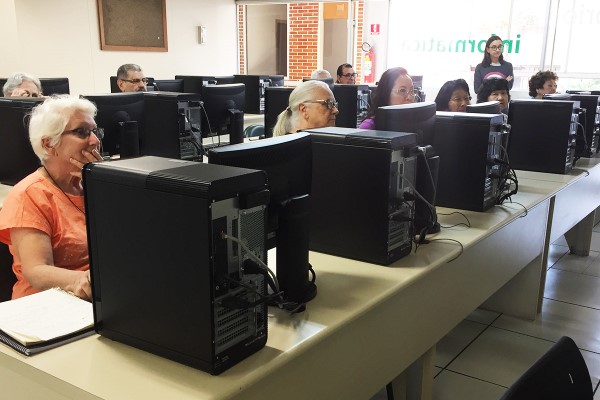 Imagem de sala de informática da fecap com pessoas da terceira idade