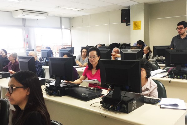 Imamge de sala de informática da fecap com pessoas da terceira idade