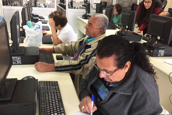Imamge de sala de informática da fecap com pessoas da terceira idade