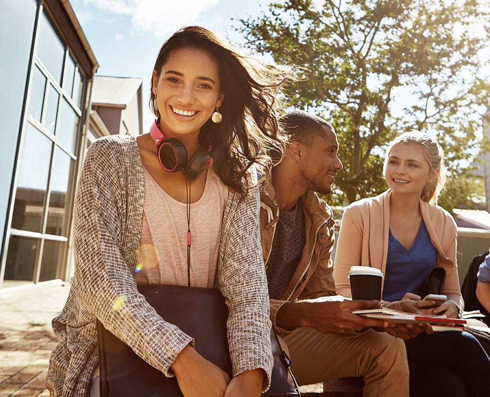 Imagem de jovens estudantes sentados e conversando em uma area livre