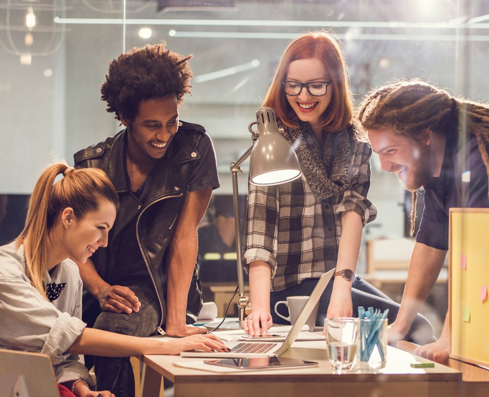 Imagem de jovens ao redor de uma mesa com um notebook